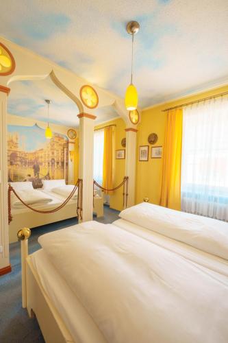a bedroom with two beds and a painting on the wall at Hotel Plankl in Altötting