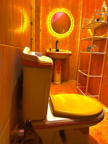 a bathroom with a yellow toilet and a sink at Safari Abu Simbel in Abu Simbel