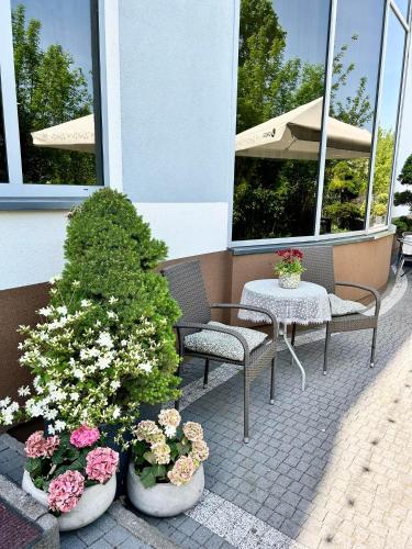 a patio with two chairs and a table and flowers at Bursztynowa in Łuków