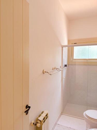 a bathroom with a shower and a toilet at Villa Coração Guesthouse by Concavus in Monte Verde