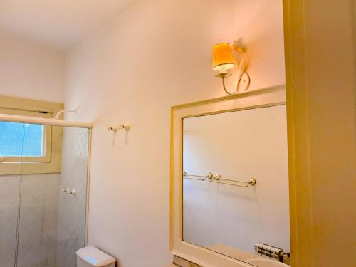 a bathroom with a mirror and a shower at Villa Coração Guesthouse by Concavus in Monte Verde