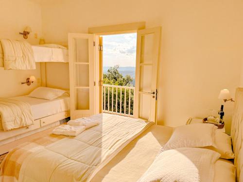 a bedroom with two bunk beds and a window at Villa Coração Guesthouse by Concavus in Monte Verde