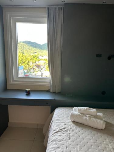 a bedroom with a window with towels on a bed at Apartamento Hardt in Pomerode