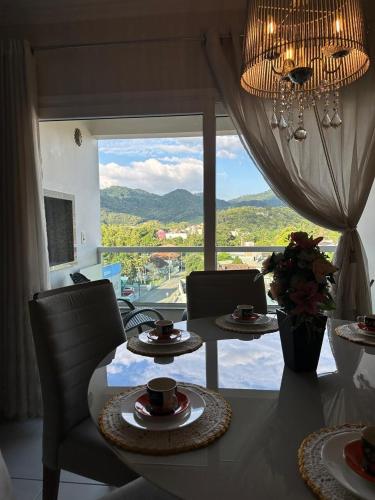 a dining room with a table and a large window at Apartamento Hardt in Pomerode
