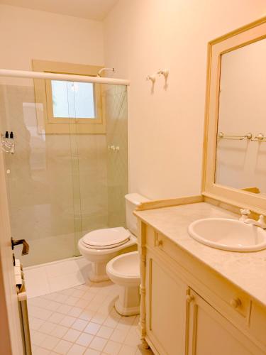 a bathroom with a toilet and a sink and a shower at Villa Coração Guesthouse by Concavus in Monte Verde