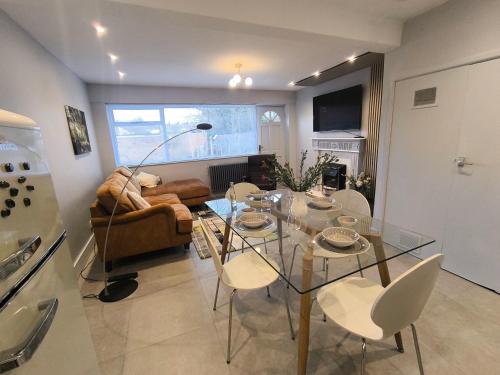 a living room with a glass table and chairs at Spotless and Spacious Manchester Home in Manchester