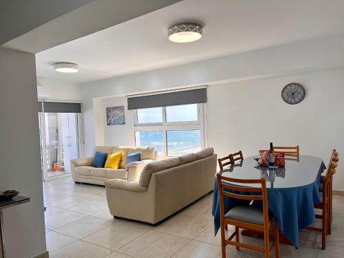 a living room with a couch and a table at Larnaca BeachHouse in Larnaka