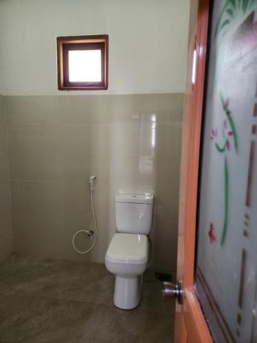 a small bathroom with a toilet and a window at Silvil Homestay in Bandarawela