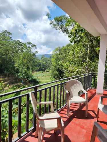a balcony with two chairs and a view of the forest at Silvil Homestay in Bandarawela