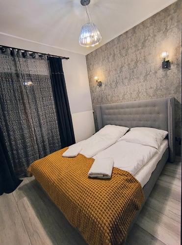 a bedroom with a large bed with a yellow blanket at Perła Górska in Szklarska Poręba