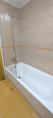 a white bath tub in a tiled bathroom at Apartamento A Cañiza in La Cañiza
