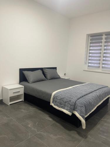 a bedroom with a bed and a white wall at Vila Mila Ćirić in Pančevo