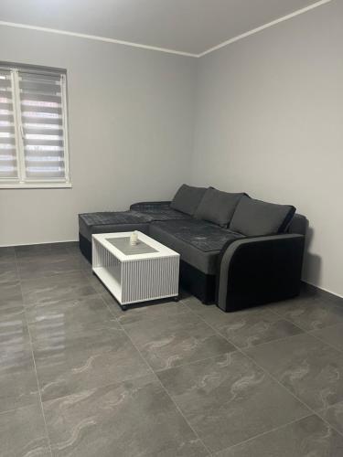 a living room with a black couch and a table at Vila Mila Ćirić in Pančevo
