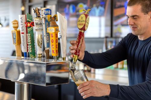 a man pouring a drink into a glass at Holiday Inn Resort Galveston - On The Beach by IHG in Galveston