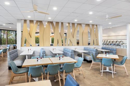 a restaurant with wooden tables and blue chairs at Holiday Inn Resort Galveston - On The Beach by IHG in Galveston