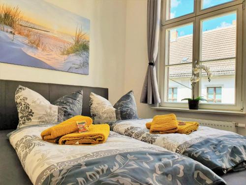 2 łóżka w pokoju z żółtymi ręcznikami w obiekcie Hogulu - im Herzen der Altstadt, Appartement 11 w mieście Brandenburg an der Havel