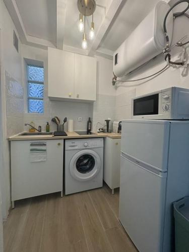 une cuisine avec un lave-linge et un réfrigérateur dans l'établissement Charmant studio centre ville jardin des plantes - Montpellier, à Montpellier