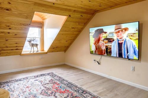 a living room with a flat screen tv on a wall at Spacious 3BR Oasis with Patio & Arcade Fun in Philly in Philadelphia