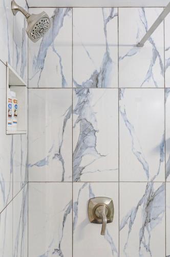 a shower with blue marble tiles in a bathroom at Spacious 3BR Oasis with Patio & Arcade Fun in Philly in Philadelphia