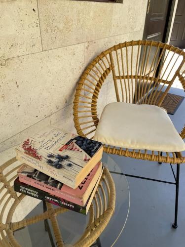 a stack of books on a glass table next to a chair at Hotel Las Hamacas in Santa Catalina