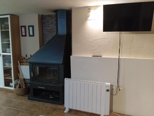 a living room with a fireplace and a television at Casa el Sereno in Salas Bajas