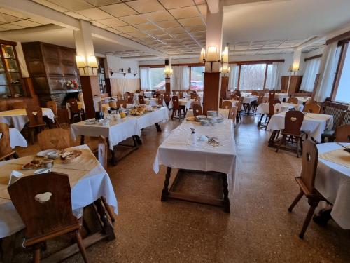 a dining room with white tables and chairs at Hotel La Cumbrecita in La Cumbrecita
