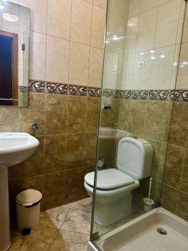 a bathroom with a toilet and a sink and a shower at Residencial Bem Estar in Chaves