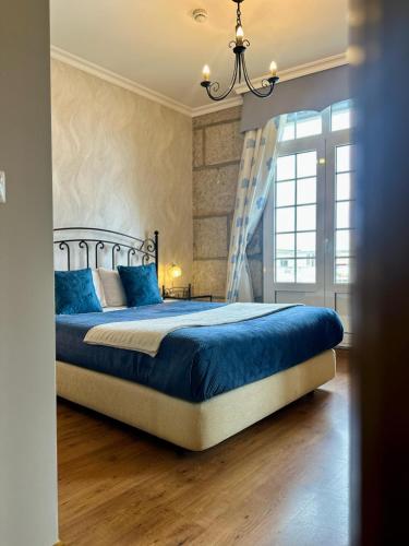 a bedroom with a bed with blue sheets and a window at Residencial Bem Estar in Chaves