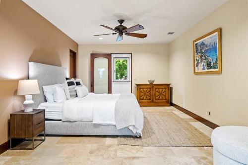 a bedroom with a white bed and a ceiling fan at Villa Allegria Luxe-Pool, Spa, Casita, Sleeps 12 in Templeton