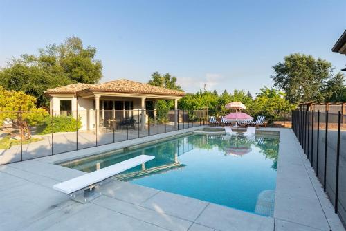 a swimming pool in front of a house with a fence at Villa Allegria Luxe-Pool, Spa, Casita, Sleeps 12 in Templeton