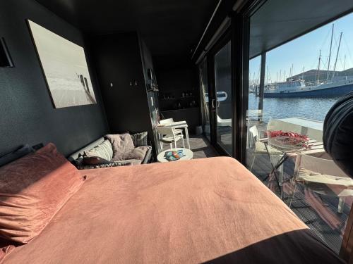 Zimmer mit einem Bett und Blick auf das Wasser in der Unterkunft Wohnboot 'TinyFloat' in Andijk IJsselmeer in Andijk