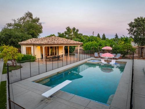 a house with a swimming pool and a fence at Villa Allegria Luxe-Pool, Spa, Casita, Sleeps 12 in Templeton