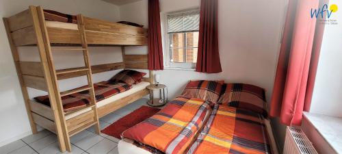 una habitación con dos literas y una ventana en Fuhrmannshof Ferienwohnung Cassen, en Juist