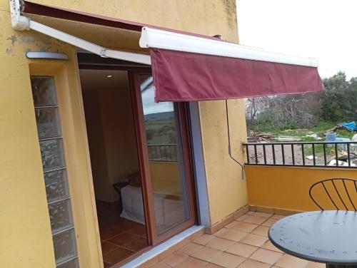 a balcony with a table and an awning at Casa el Sereno in Salas Bajas