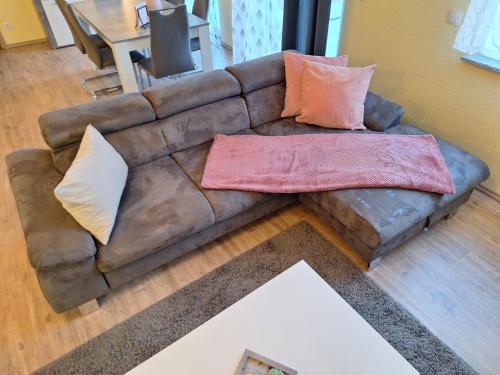 a brown leather couch with pillows on it in a living room at Neue Ferienwohnung auf dem Land in Boppard