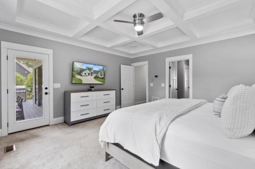 a bedroom with a white bed and a television on a dresser at Vibes n Tides in Terrell