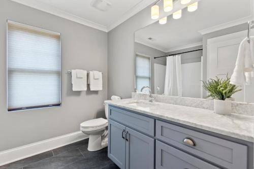 a bathroom with a sink and a toilet and a mirror at Vibes n Tides in Terrell