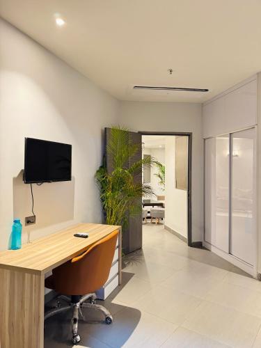 an office with a desk and a tv on the wall at 2 bhk supernova in Noida