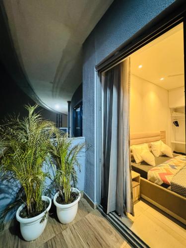 two potted plants in a room with a bedroom at 2 bhk supernova in Noida