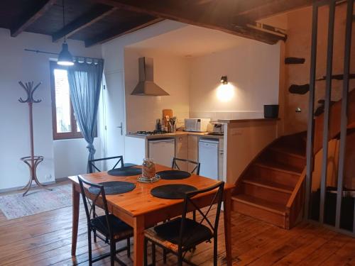 une cuisine et une salle à manger avec une table et des chaises dans l'établissement Gite La maison de Popey, à Saint-Romain-de-Popey