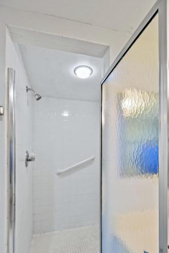 a shower with a glass door in a bathroom at Beach Club 327 in East End