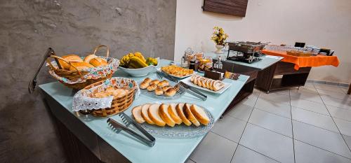 a table topped with lots of different types of food at Hotel Parati in Parapuã