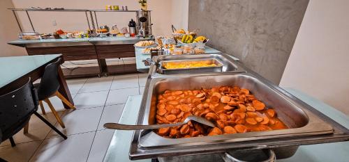 a buffet with a large tray of food on a table at Hotel Parati in Parapuã