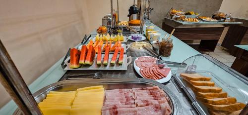 a buffet with many different types of meats and cheese at Hotel Parati in Parapuã