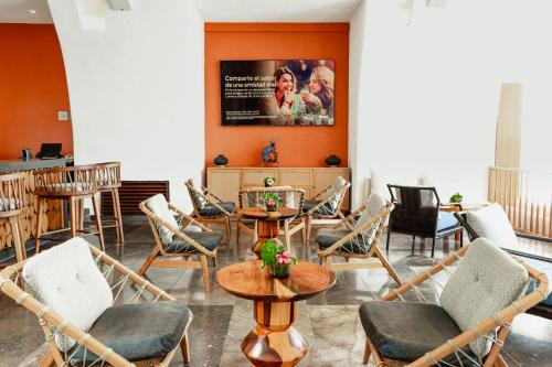a restaurant with chairs and tables and a poster on the wall at Camino Real Zaashila Huatulco in Santa Cruz Huatulco