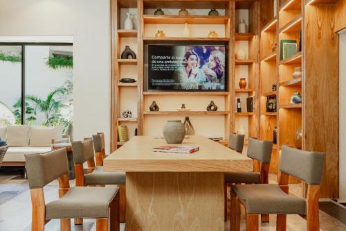 a dining room with a table and a tv at Camino Real Zaashila Huatulco in Santa Cruz Huatulco
