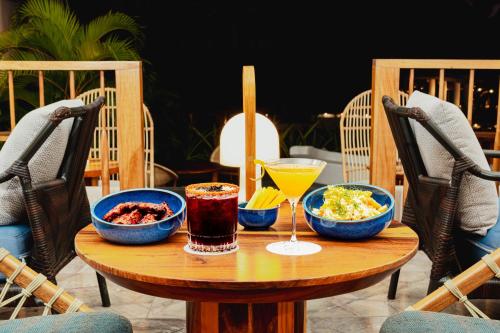 a wooden table with bowls of food and drinks on it at Camino Real Zaashila Huatulco in Santa Cruz Huatulco