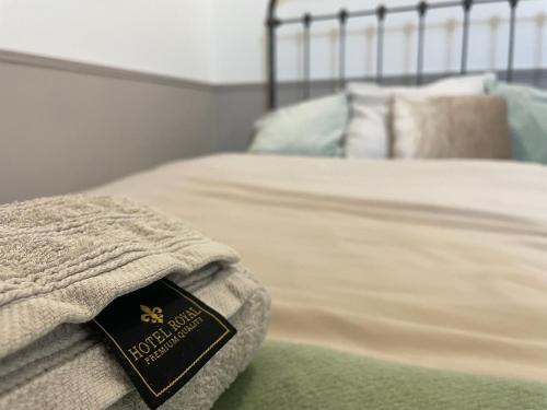 un livre assis au bout d'un lit dans l'établissement Chambre XL, bureau & salle de bain privative - Centre ville de CREIL, à Creil