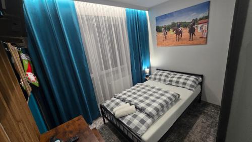 a small bedroom with a bed and a picture on the wall at Pensjonat Lubianka in Starachowice