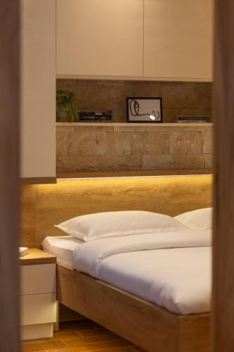 a bedroom with a bed with a wooden headboard at 42° North Apartments in Tivat